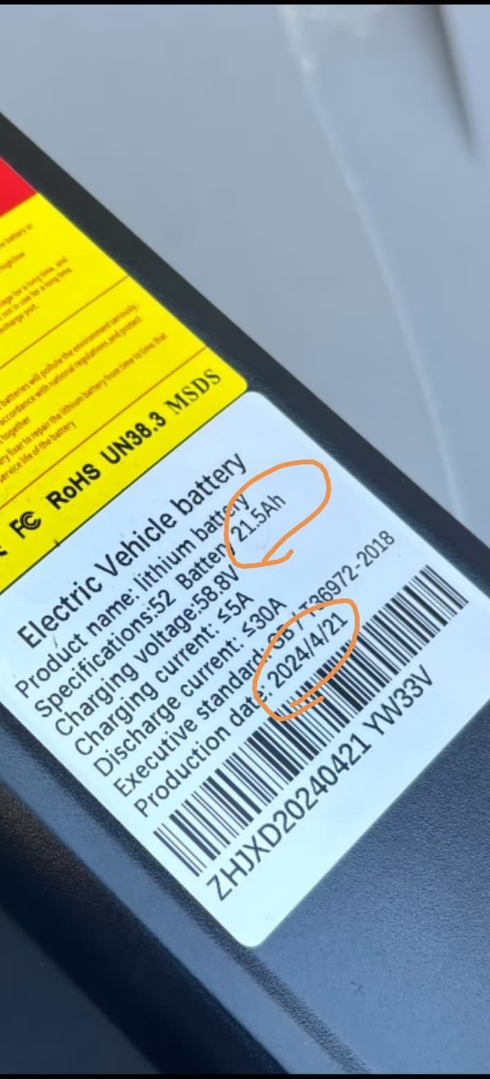 The battery's capacity (21.5Ah) and the production date (2024/4/21) are printed on a label on the front of the battery