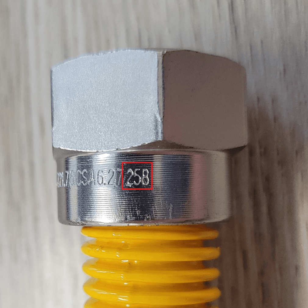 Close-up view of the flare nut on the recalled gas connector with date of manufacture engraving