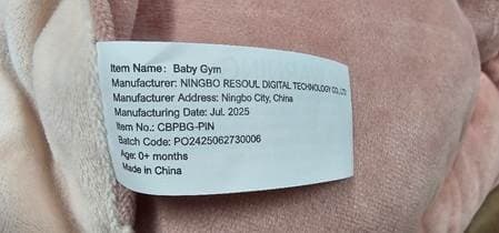 "Baby Gym" and "Item No.: CBPBG-PIN" are printed on a label stitched to the product on the edge of the mat at the bottom